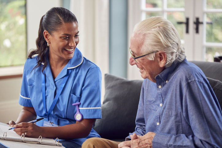 A nurse talks with an elderly man in a nursing home. The blog is about reducing energy costs for care homes.