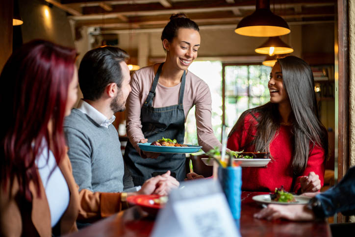 Waitress Working In Traditional English Pub Serving Breakfast To Guests. Smart lighting processes can help reduce pubs energy bills.